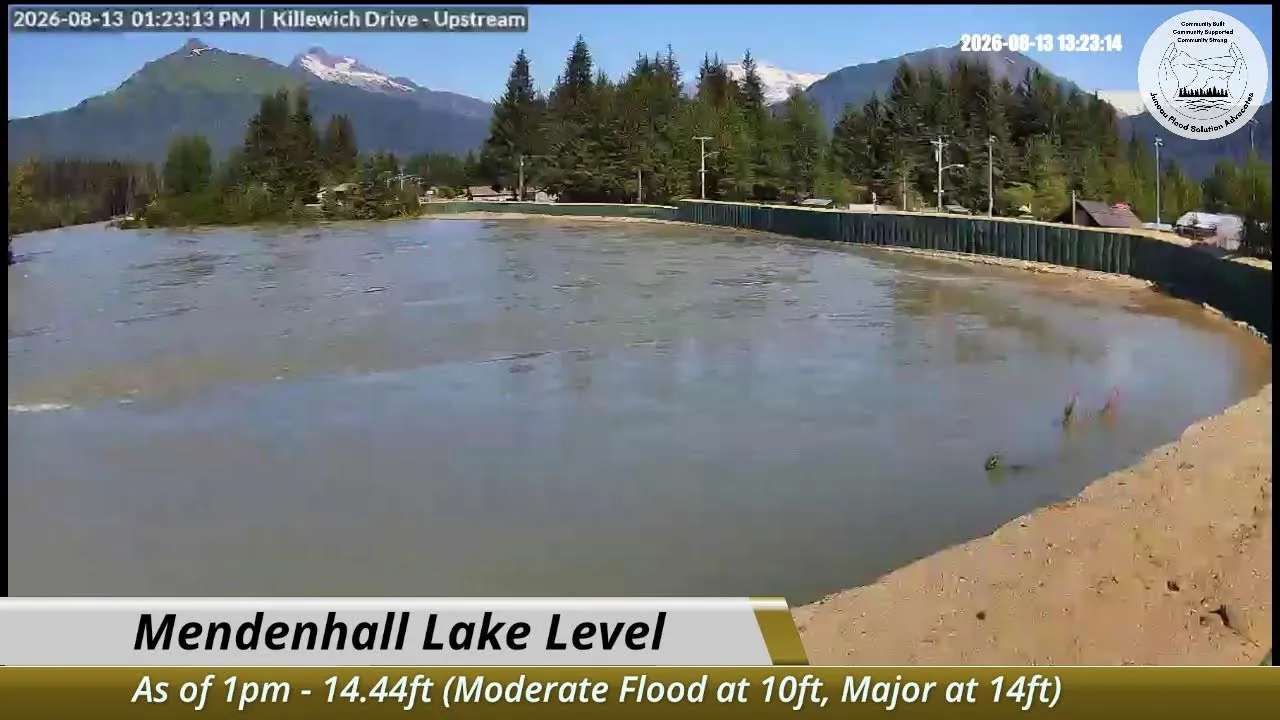 The Mendenhall River at Killewich Drive on August 13, 2026, filling the channel to the top of the temporary barrier near the flood crest
